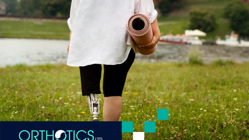 Yoga and Stretching for Lower Limb Amputees - Featured An amputee woman with a prosthetic leg is carrying a yoga mat outdoors