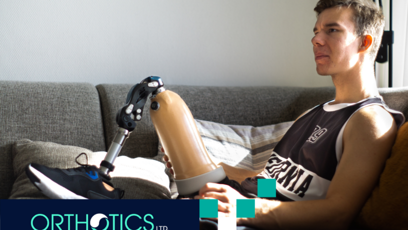 Psychological Benefits of Wearing Custom Prosthetics - featured An amputee wearing prosthetics sitting on a couch