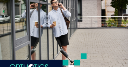 An amputee with a prosthetic limb is on the phone while holding a cup of coffee