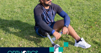 An amputee wearing prosthesis sitting on the grass