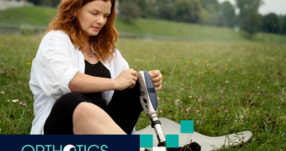 A woman wearing a prosthetic sitting on grass