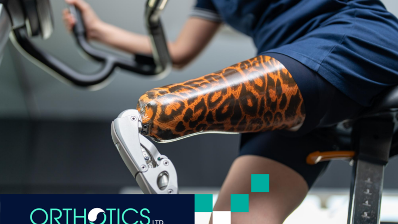 An amputee wearing a prosthetic riding a stationary bicycle