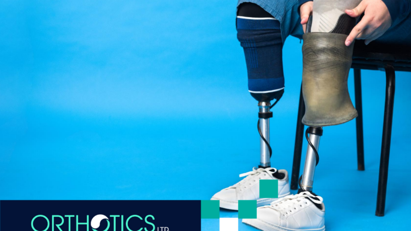 A perosn wearing prosthetics sitting on a chair with a blue background