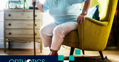 An elderly woman standing up using a cane